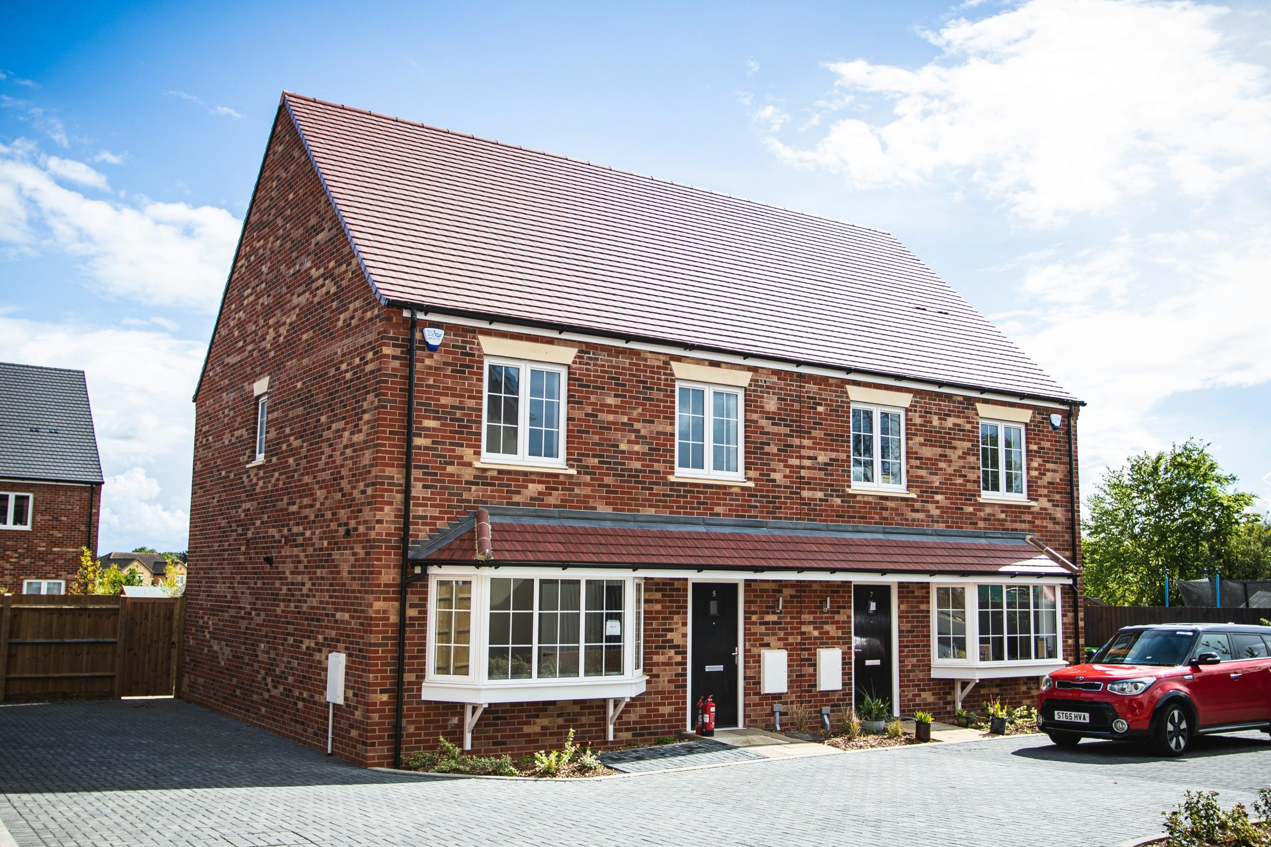 residential property with red car parked outside